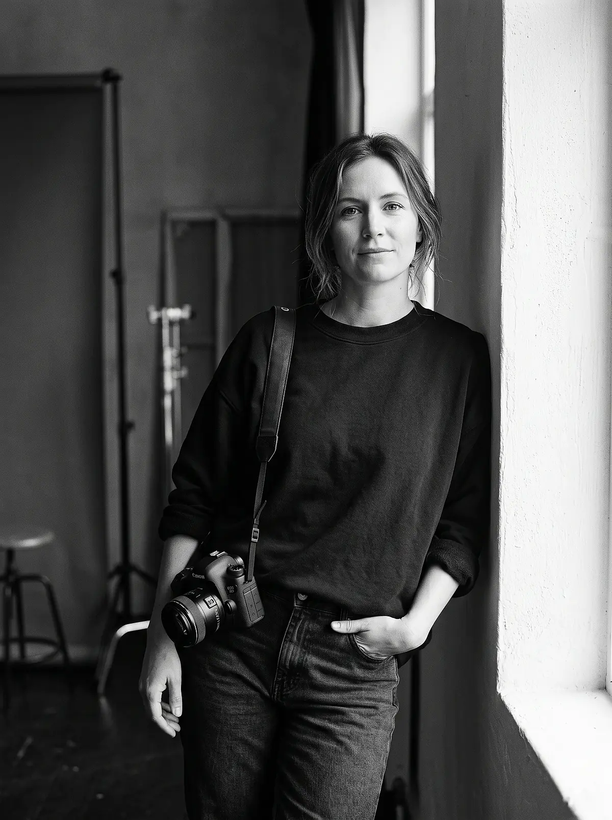 Black and white portrait of Ondine Reyes with a camera over her shoulder.