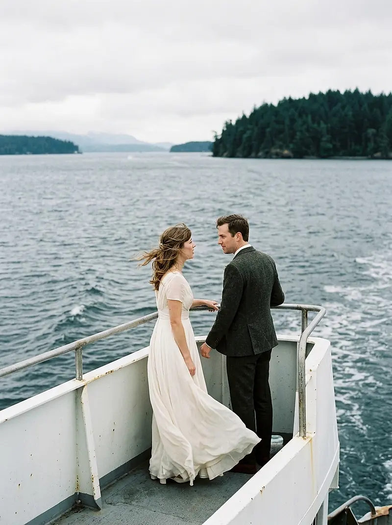 A bride and groom on the deck of a ferry crossing Puget Sound.