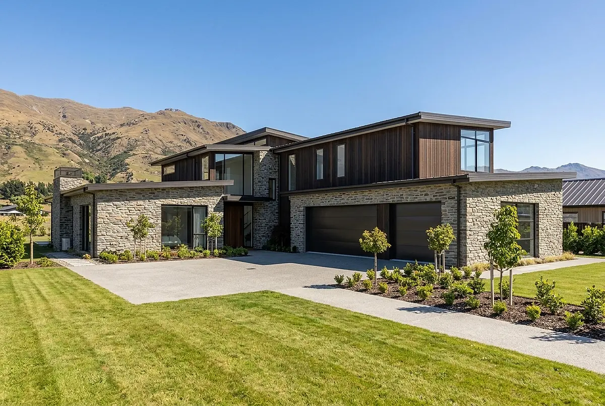 The five bedroom house at 3305 Kestrel Way, with stone and timber cladding and the foothills behind