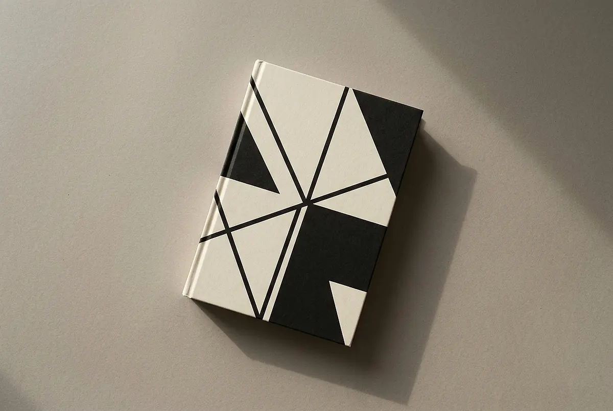 A hardcover book with an abstract geometric cover on a plain surface