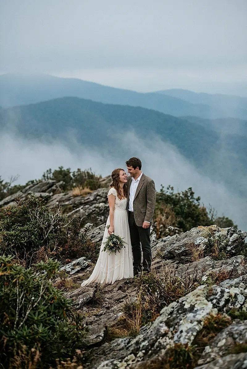 A couple in simple wedding clothes on a Blue Ridge overlook in the morning mist