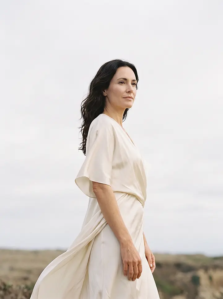 Marisol Grant in an ivory dress, photographed against a pale sky