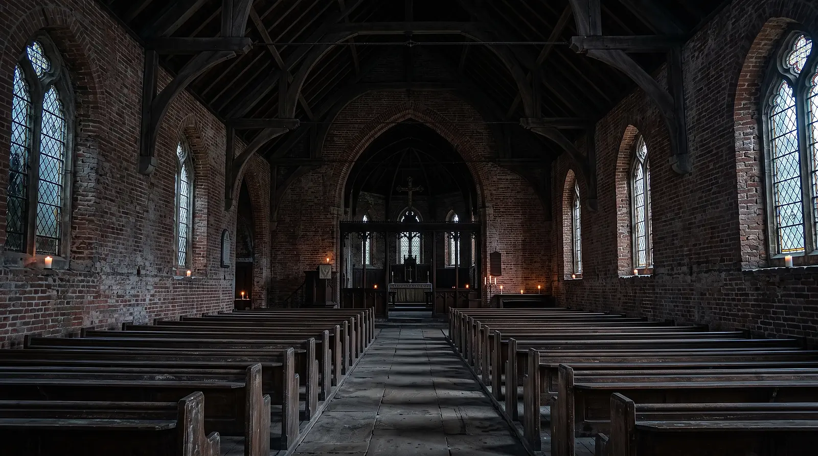 The nave of St. Brendan's, pews and brick walls in low evening light